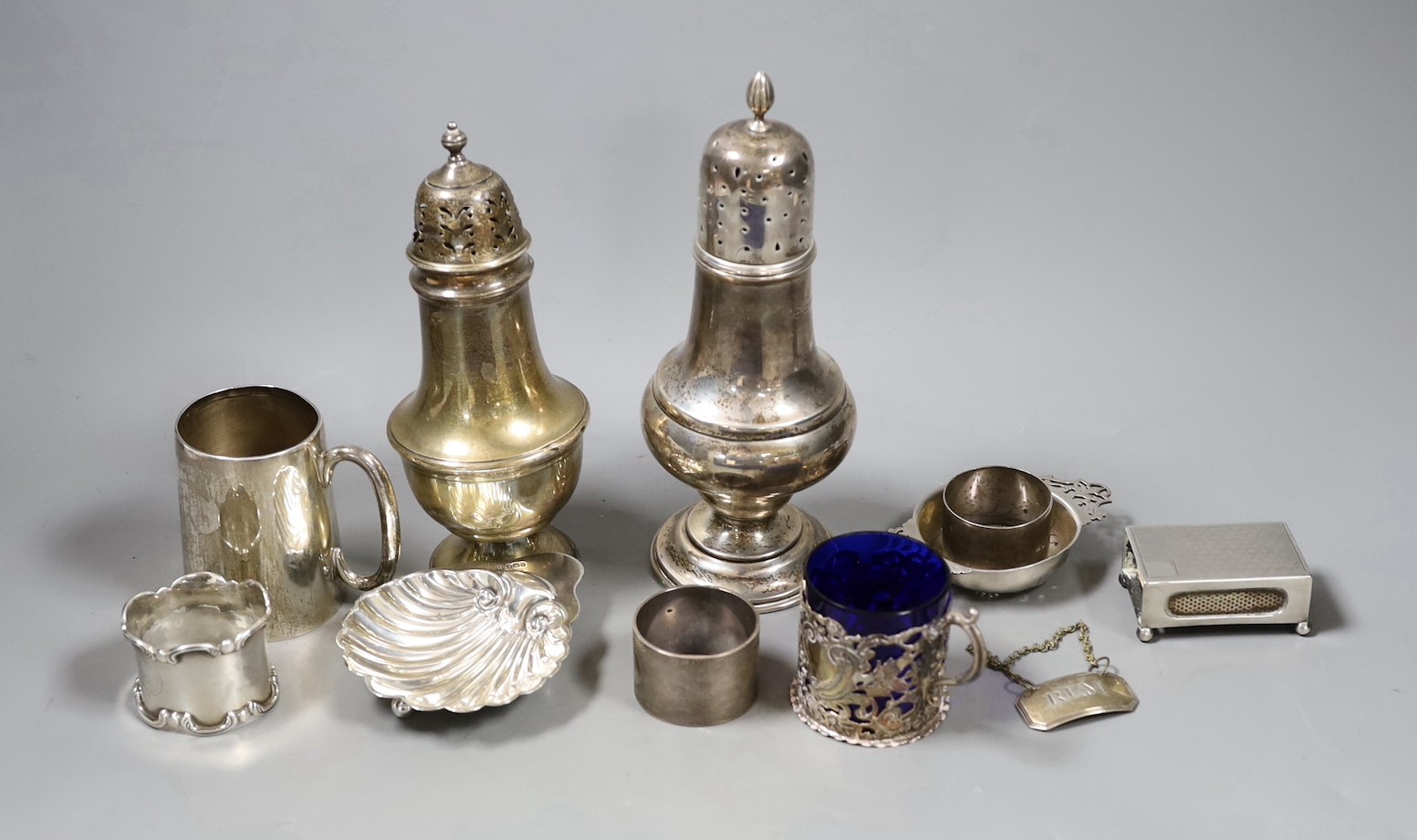 Sundry small silver including two sugar casters, tallest Chester, 1922, 21cm, two mugs, match sleeve, quaich, wine label and three napkin rings